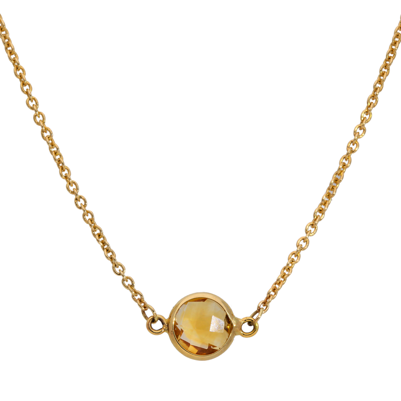 Gold necklace with a round yellow gemstone on a white background