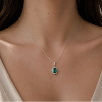 18ct white gold emerald and diamond pendant necklace with a central emerald gemstone and sparkling diamonds.