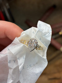 A close-up of The Aurelia Pear Diamond Ring by Appleby Jewellers Dublin, showcasing a pear-shaped diamond set in a elegant gold band.
