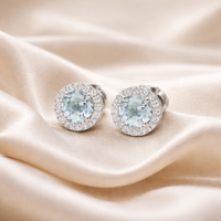Aquamarine and diamond halo stud earrings in 18ct white gold with sparkling gemstone accents, designed for elegant style.