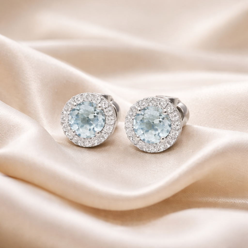 Aquamarine and diamond halo stud earrings in 18ct white gold with sparkling gemstone accents, designed for elegant style.