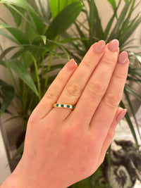 18ct emerald and princess diamond channel eternity ring showcasing sparkling gemstones set in a sleek gold band.