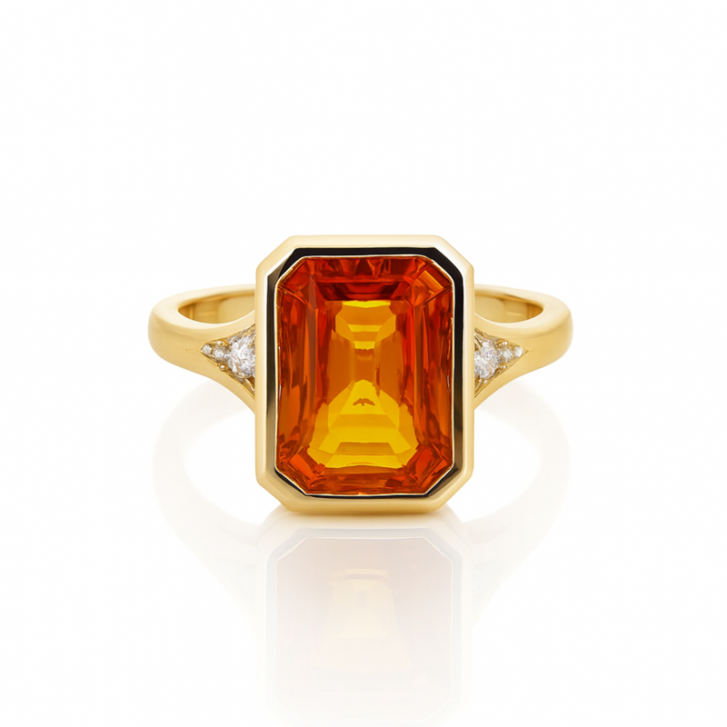 Gold ring with a large orange gemstone and smaller diamonds on a white background