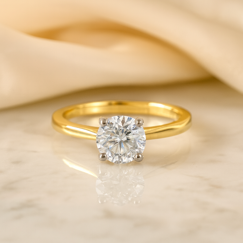Gold ring with a diamond on a beige fabric background
