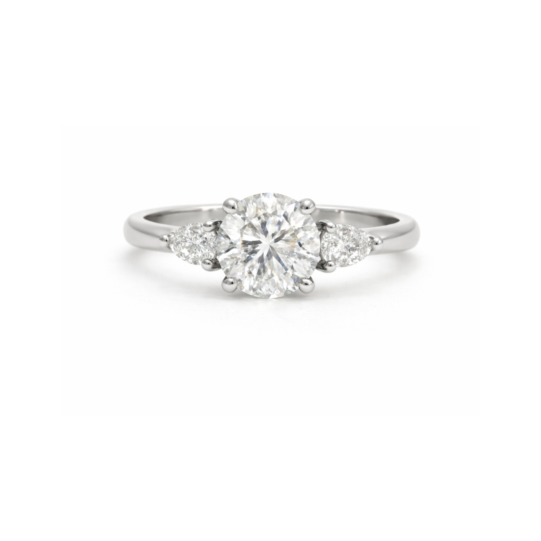 Elegant diamond ring featuring a 1.01ct round brilliant center stone with pear-shaped side diamonds by Appleby Jewellers Dublin.